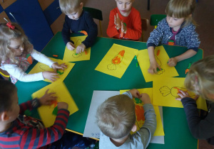 Dzieci z "Biedronek" wypełniają plasteliną sylwety marchewek