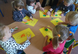 Dzieci z "Biedronek" wypełniają plasteliną sylwety marchewek