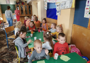 Dzieci zjadają ciasto marchewkowe i piją sok z marchewki