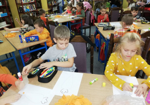 Dzieci z "Wiewiórek" wykonują pracę plastyczną - wypełnianie kulkami z bibuły sylwety marchewki