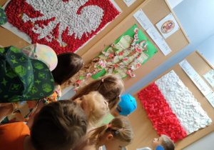 Dzieci z grupy "Pszczółek" podziwiają wystawę pt. "Narodowe dekoracje".