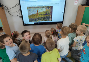 Oglądamy obrazy Georgesa Seurata, na których dominują kropki (pointilizm) na ekranie multimedialnym.