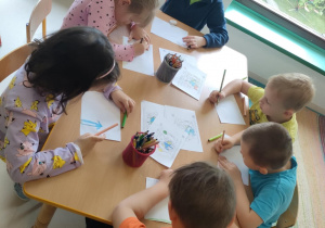 Dzieci przy stolikach rysują swojego przyjaciela/swoją przyjaciółkę.