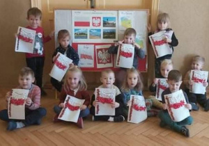 Dzieci z grupy Biedronki pozują do pamiątkowego zdjęcia razem ze swoimi flagami