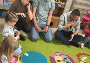 Nawijamy na szpulkę sznurek z obrazkiem żabki, ćwicząc w ten sposób sprawność rączek.