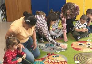Nawijamy na szpulkę sznurek z obrazkiem żabki, ćwicząc w ten sposób sprawność rączek.