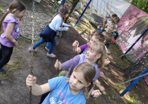 Dzieci podczas zabawy swobodnej na świeżym powietrzu na leśnej polanie w "Malinowym Grodzie".