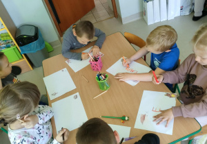 "Miś, jeż i EMPATIA" - kilkoro dzieci w trakcie tworzenia rysunku na podany temat.