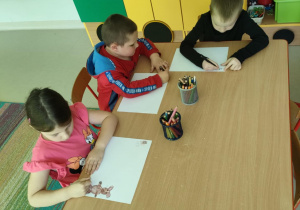 "Miś, jeż i EMPATIA" - kilkoro dzieci w trakcie tworzenia rysunku na podany temat.