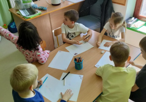"Miś, jeż i EMPATIA" - kilkoro dzieci w trakcie tworzenia rysunku na podany temat.