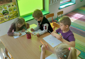 "Miś, jeż i EMPATIA" - kilkoro dzieci w trakcie tworzenia rysunku na podany temat.