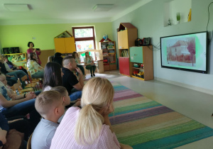 Goście oglądają film o historii naszej placówki na ekranie multimedialnym.