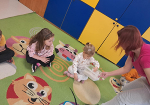 Dzieci z grupy "Żabek" sprawdzają, jaki jest w dotyku pyłek wulkaniczny.