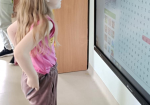 "Pszczółki" wyszukują i wykreślają nazwy zwierzątek domowych na ekranie multimedialnym.