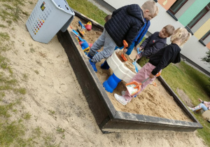 Dzieci podczas zabawy w piaskownicy na ogrodzie przedszkolnym.