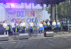 Zadowolone dzieci z grupy najstarszej stoją na scenie po wykonaniu tańca MIX kołysanka APT.