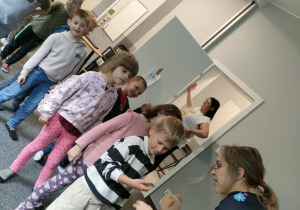 Pani Weronika wręcza dzieciom tatuaże.