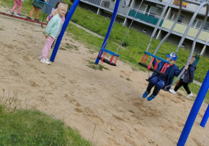 Dzieci swobodnie bawią się na placu zabaw.