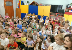 Dzieci głośno śpiewają piosenkę na powitanie podczas audycji muzycznej.
