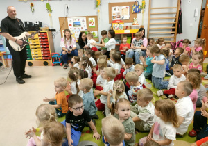 Przedszkolaki oglądają występ swoich rówieśników.