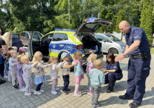 Funkcjonariusze Policji wręczają "Wiewiórkom" upominki.