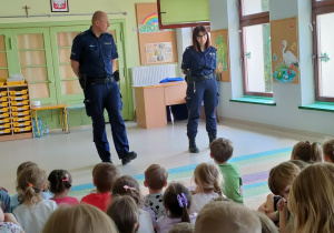 Funkcjonariusze Policji podczas prowadzenia pogadanki z dziećmi starszymi o bezpiecznych wakacjach.