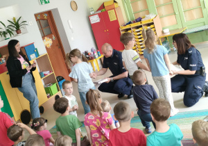 Wybrane dzieci wręczają przybyłym Gościom podziękowania.