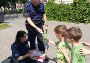 Funkcjonariusze Policji wręczają "Motylkom" upominki.