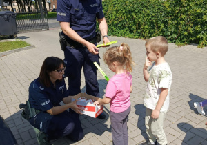 Funkcjonariusze Policji wręczają "Motylkom" upominki.