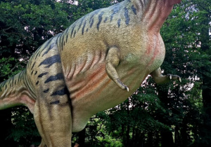 Dzieci podziwiają ogromnego dinozaura.