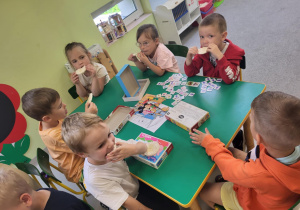 Dzieci smakują miód na wafelkach ryżowych.