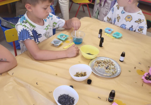 Dzieci podczas warsztatów tworzą swoje zapachowe mydełka.