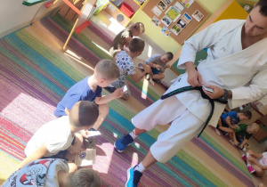 Sensei Łukasz wręcza "Pszczółkom" ulotki informacyjne, dotyczące zajęć karate.