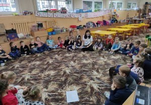 Dzieci z grupy "Kaczuszki" i "Skrzaty" słuchają wiersza pt. "Dzień życzliwości".