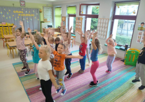 Rozgrzewka ruchowa - dzieci licząc do 10-ciu, wykonują "pajacyki".