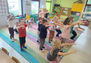Rozgrzewka ruchowa - dzieci licząc do 12-stu, wykonują "przysiady".