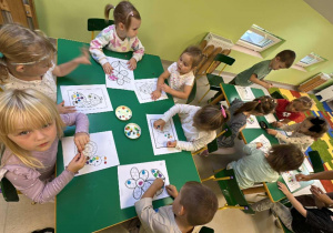 Kilkoro dzieci z grupy "Żabek" podczas kropkowanej pracy plastycznej z wykorzystaniem plasteliny.