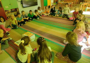Dzieci siedzą na dywanie podczas "burzy mózgów".