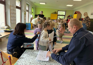 Dzieci otrzymują upominki od policjantów po skończonych zajęciach.