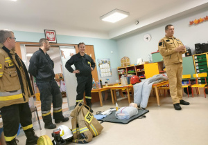 Strażacy z OSP w Ozorkowie rozmawiają z dziećmi młodszymi o swojej pracy.