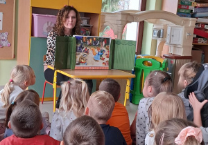 Wychowawczyni grupy Pszczółek czyta dzieciom treść scenki "Jesienny bal w lesie".