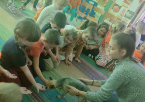 Dzieci podają pieskowi smaczki.