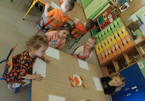 "Jeżyki" gotowe do pracy plastycznej z wykorzystaniem mandarynki oraz pomarańczowej farby.