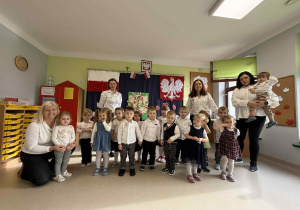 Dzieci z grupy "Jeżyków" na tle patriotycznej dekoracji.