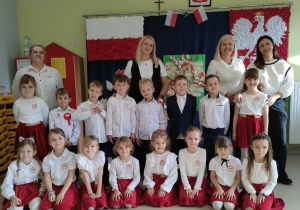 Dzieci z grupy "Motylków" na tle patriotycznej dekoracji.