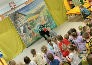 Aktywny udział chętnych dzieci - chłopiec sypie ziarenka zwierzętom gospodarskim.