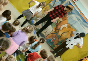 Aktywny udział chętnych dzieci - dziewczynka naśladuje grabienie ziemi.