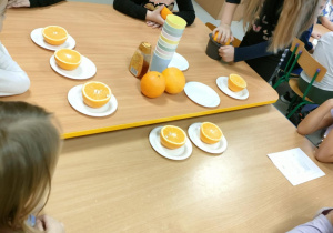 Dziewczynki po kolei wyciskają sok, przy użyciu ręcznej wyciskarki.