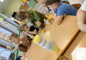 Chłopcy po kolei wyciskają sok, przy użyciu ręcznej wyciskarki.