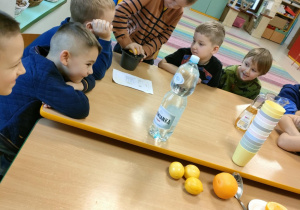 Chłopcy po kolei wyciskają sok, przy użyciu ręcznej wyciskarki.